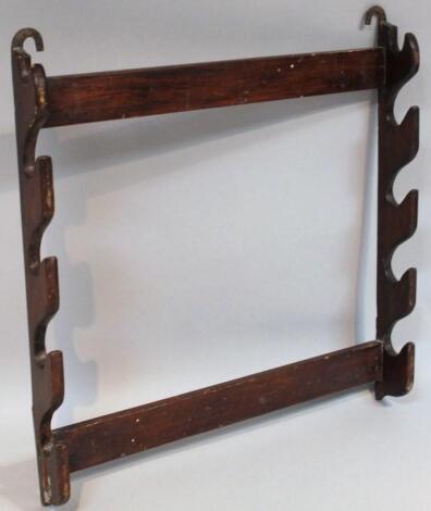 An early 20thC stained pine hanging gun rack