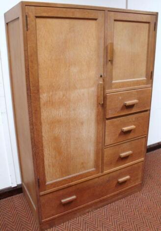 An early 20thC limed oak Heals style compactum wardrobe