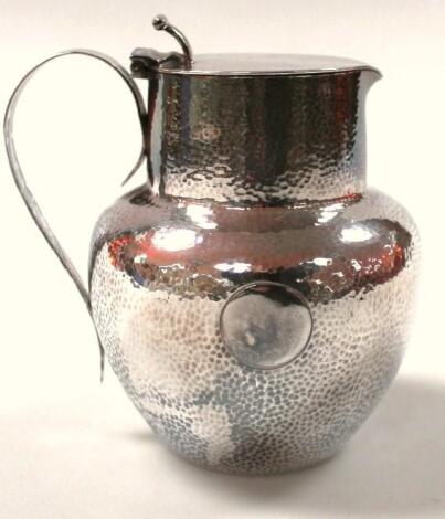 A late 19thC hammered silver plated Arts & Crafts style jug