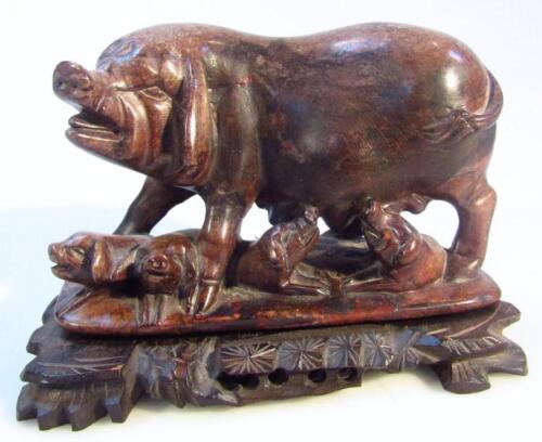 A 20thC polished hard stone figure of a sow and piglets