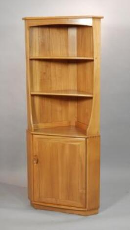 An Ercol light elm standing corner cabinet