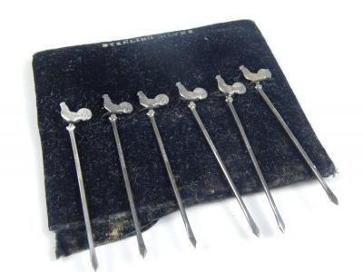 A set of six white metal cocktail sticks