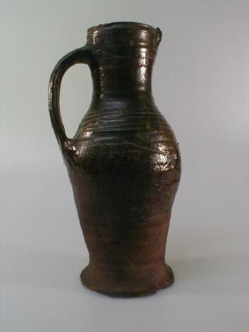 A Medieval jug, probably 14thC, of slender baluster shape, in reddish brown