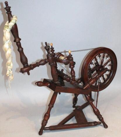 An early 20thC stained spinning wheel