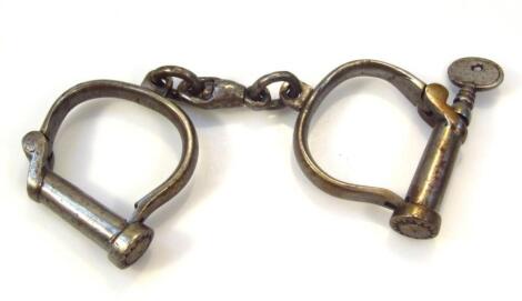 A pair of early 20thC heavy metal handcuffs