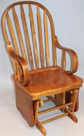 A 20thC oak finish stickback rocking chair