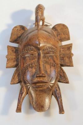 A heavily carved African tribal hardwood face mask