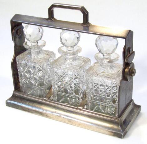 A mid-20thC metal cased three bottle tantalus