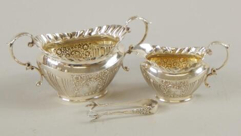 A late Victorian silver two handled sugar bowl and matching cream jug