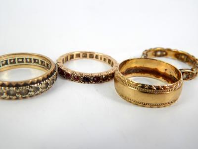 Three yellow metal and gem set eternity rings
