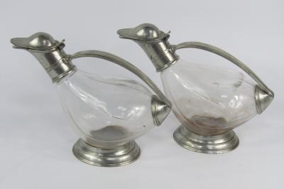 A pair of Continental cut glass and pewter mounted claret jugs