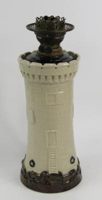 A stoneware oil lamp modelled as a lighthouse