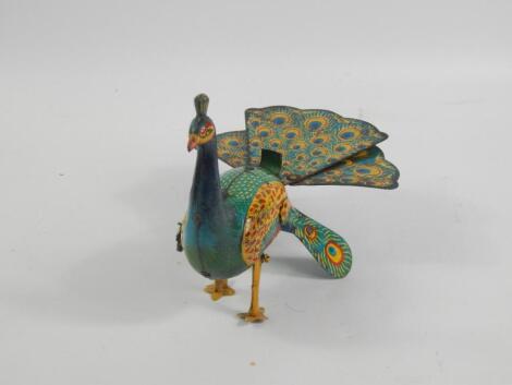 A tin plate clockwork model of a walking peacock