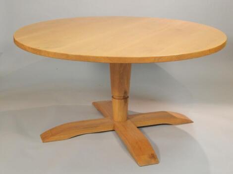 A modern light oak circular dining table
