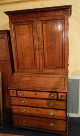 An early 19thC oak and mahogany crossbanded bureau bookcase