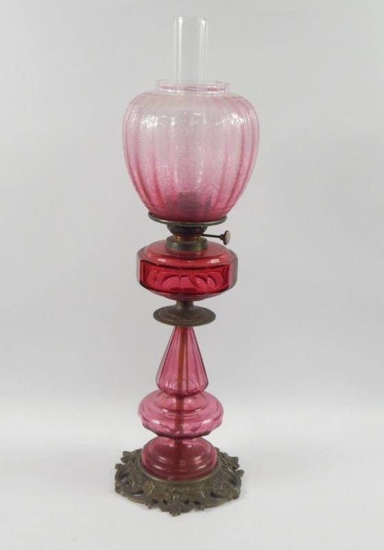 A Hinks & Son cranberry glass and brass oil lamp