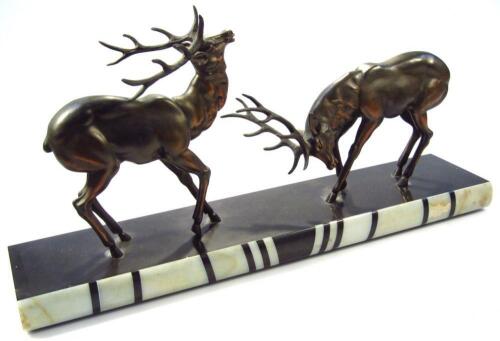 An Art Deco spelter and marbled figure group of rutting deer