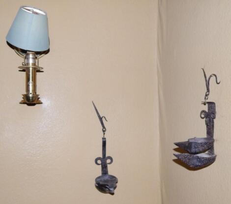 Two wrought iron wall mounted oil lamps