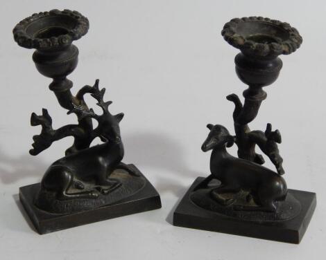 A pair of early 19thC bronze figural candlesticks