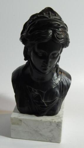 A black pottery bust of a young Grecian woman