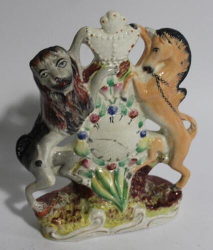 A mid-19thC Staffordshire flatback lion and unicorn clock group