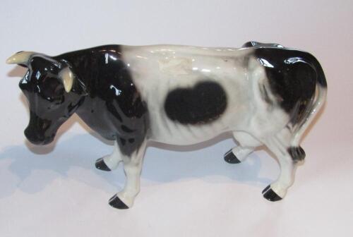 A 20thC pottery figure of a standing Friesian cow