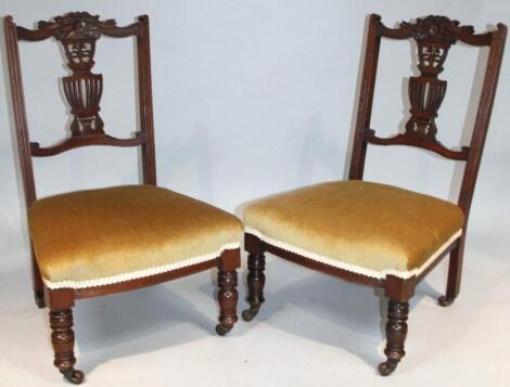 A pair of Edwardian stained walnut nursing chairs