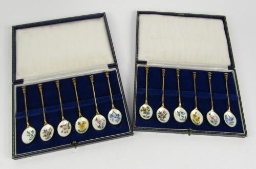 Two sets of silver gilt and enamel seal top teaspoons