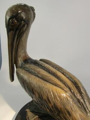 A pottery figure of a pelican perched on a tree trunk - 2