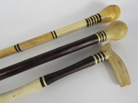 Three Victorian marine ivory and ebony walking sticks