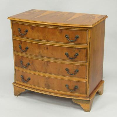 A yew wood bow front chest of four long drawers