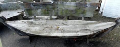 A galley type wooden garden bench