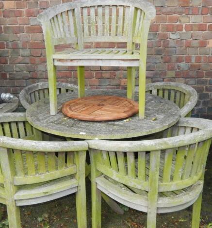 A circular garden table and four tub chairs.