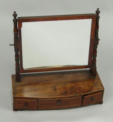 A George III mahogany and boxwood line inlaid bow fronted toilet mirror