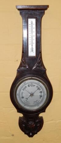 An early 20thC ebonised and carved oak wheel barometer