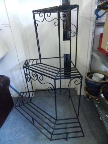 A modern wrought iron three tier corner plant stand