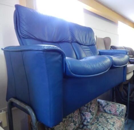 A modern blue leather two seat reclining sofa