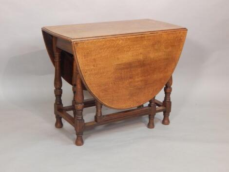 A 20thC oak oval drop leaf table