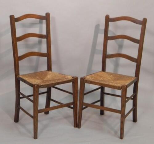 A pair of early 20thC oak ladderback bedroom chairs