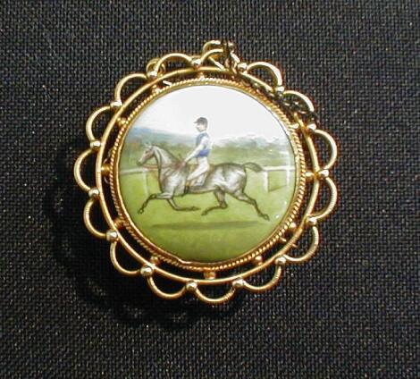 An Edwardian circular brooch with painted porcelain plaque of a horse and