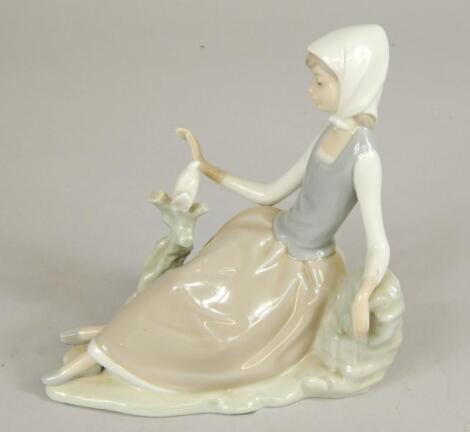 A Lladro model of a recumbent lady with a bird