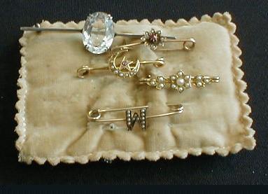 Four small gold bar brooches; a seed pearl set letter M