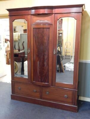 An Edwardian mahogany and tulip wood banded triple wardrobe