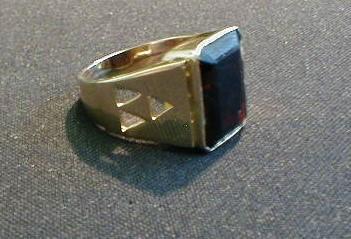 A gentleman's signet ring in rose gold set with an emerald cut garnet