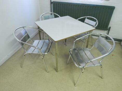 A modern white finish cafe table and four chairs.