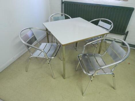 A modern white finish cafe table and four chairs.