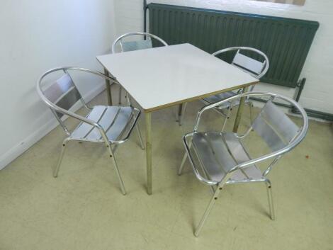 A modern white finish cafe table and four chairs.