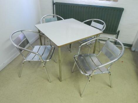 A modern white finish cafe table and four chairs.