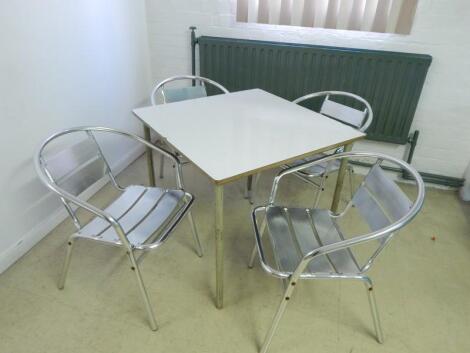 A modern white finish cafe table and four chairs.