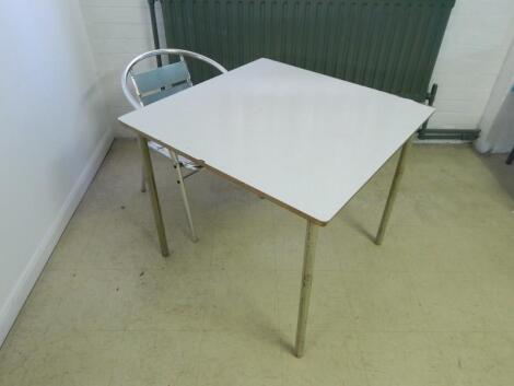 A modern white finish cafe table and one chair.